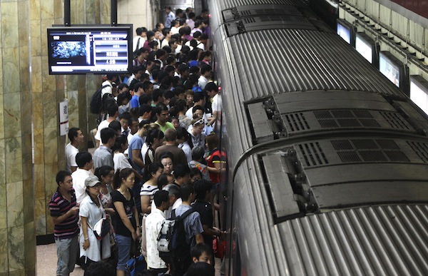 Passengers board a train at a subway station in Beijing
